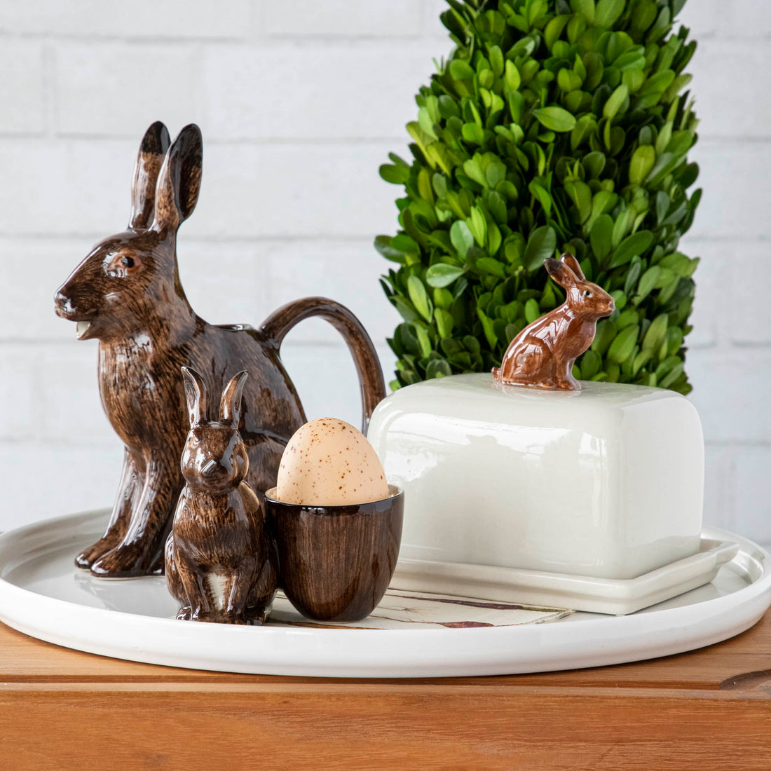 A hand-painted tray with two rabbits and an egg on it by British brand Hare Ceramics.