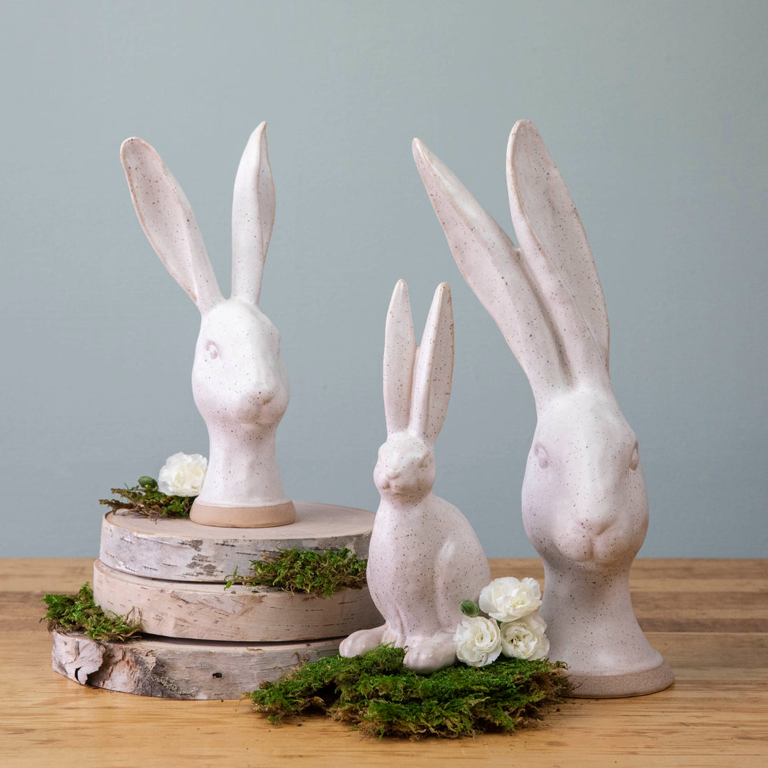 Three enchanting HomArt Matte White Ceramic Hares, ceramic rabbit heads on top of a wooden table.