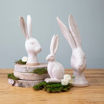 A group of enchanting Matte White Ceramic Hares by HomArt on a wood surface.