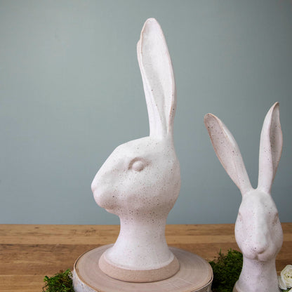 An enchanting HomArt Matte White Ceramic Hares gracefully rest on a wood surface, adding a touch of charm and whimsy as a garden decoration.
