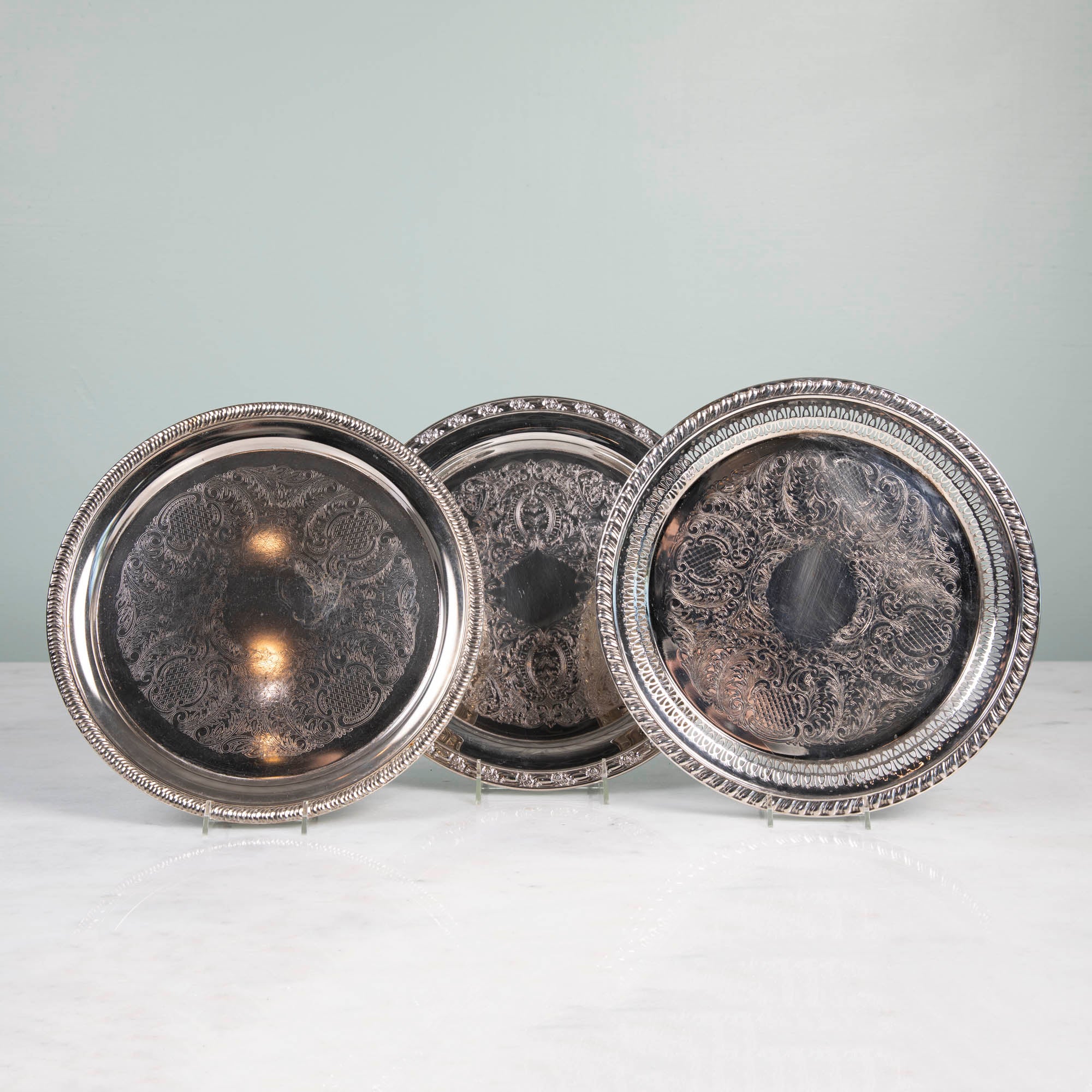 Three round vintage silver-plate trays.