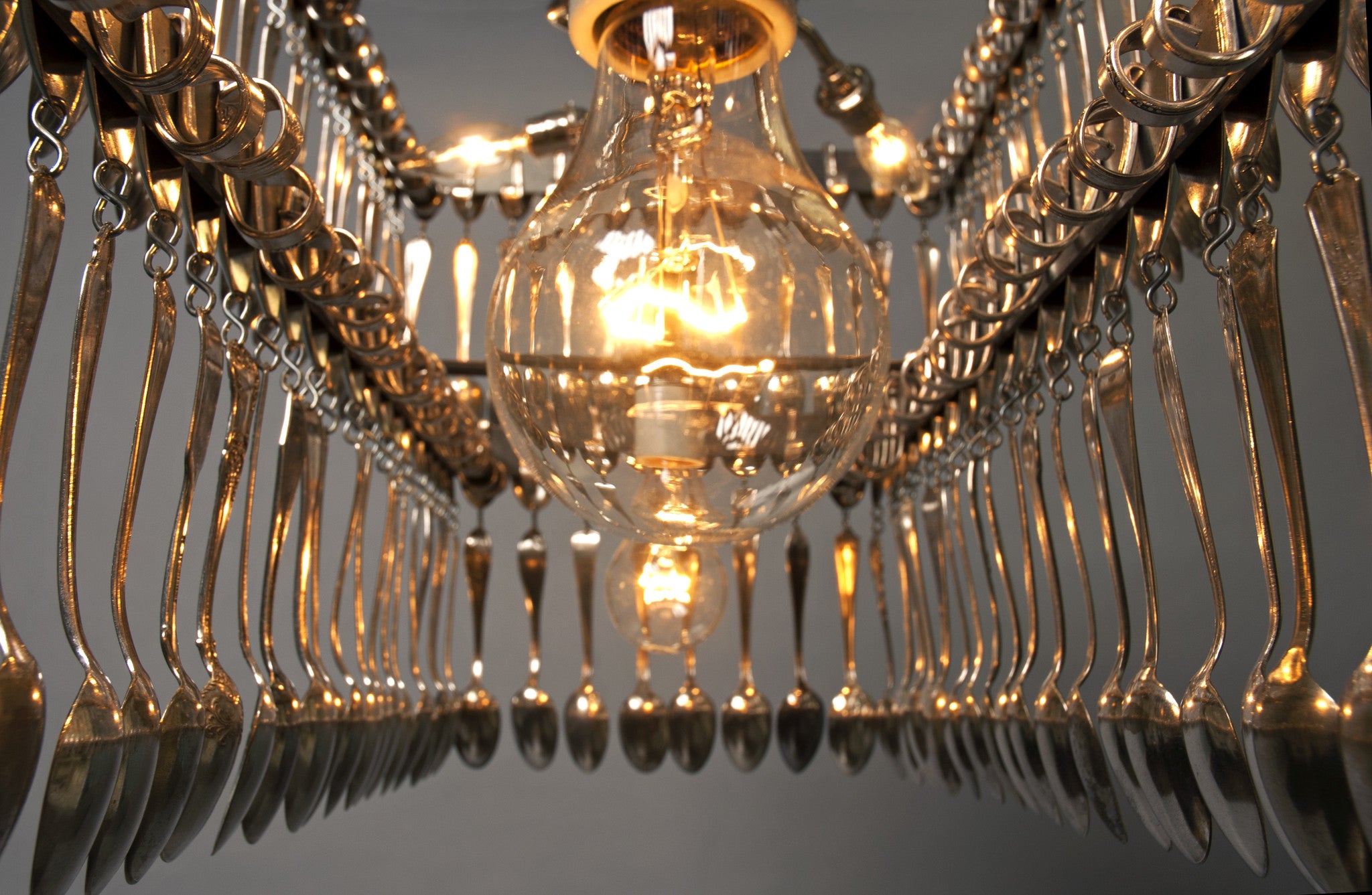 Double Tier Rectangular Spoondelier with multiple reflective pendants against a gray background by Hester &amp; Cook.