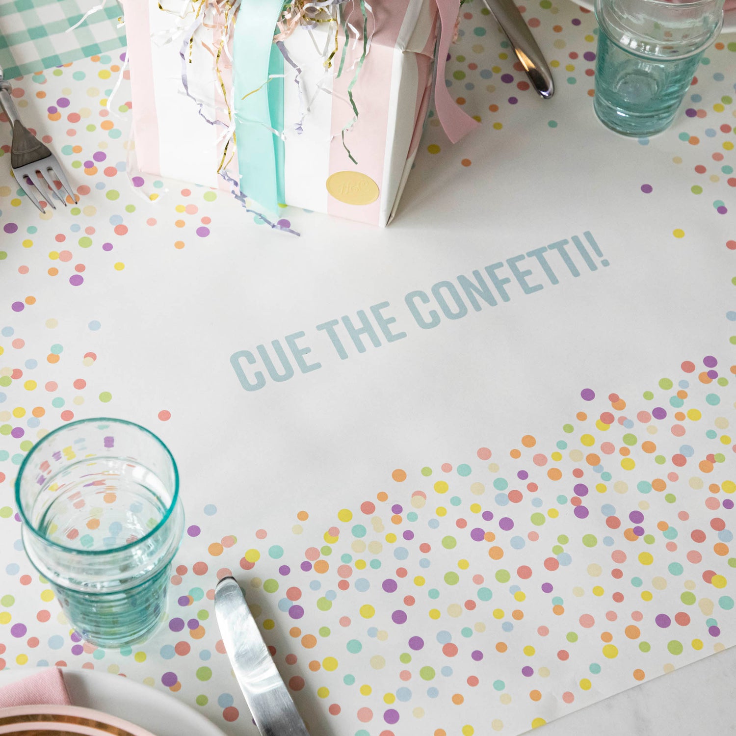 The Confetti Sprinkles Personalized Runner under a birthday table setting, with &quot;CUE THE CONFETTI!&quot; printed in blue.
