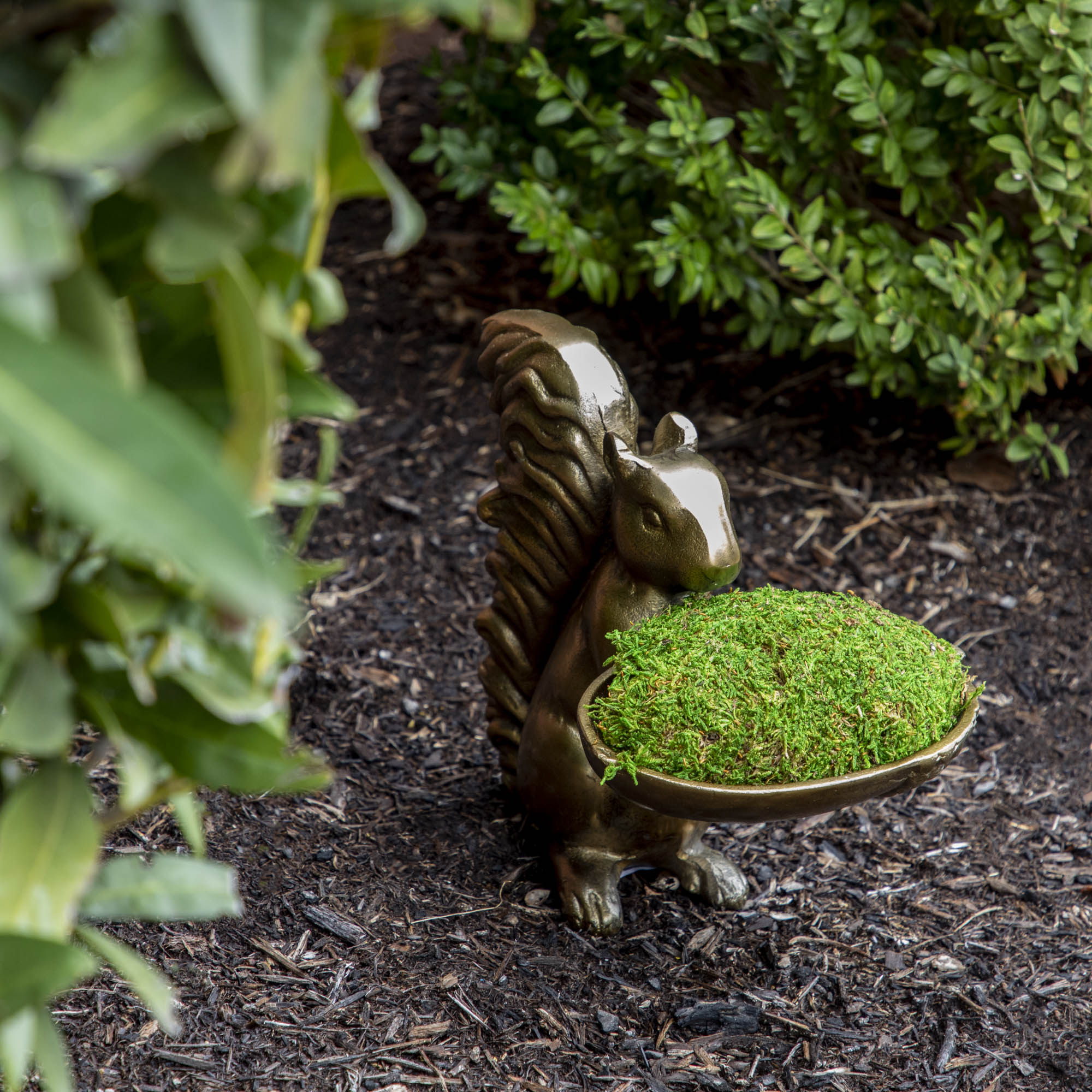 A bronze Accent Decor squirrel holding a bowl of moss.