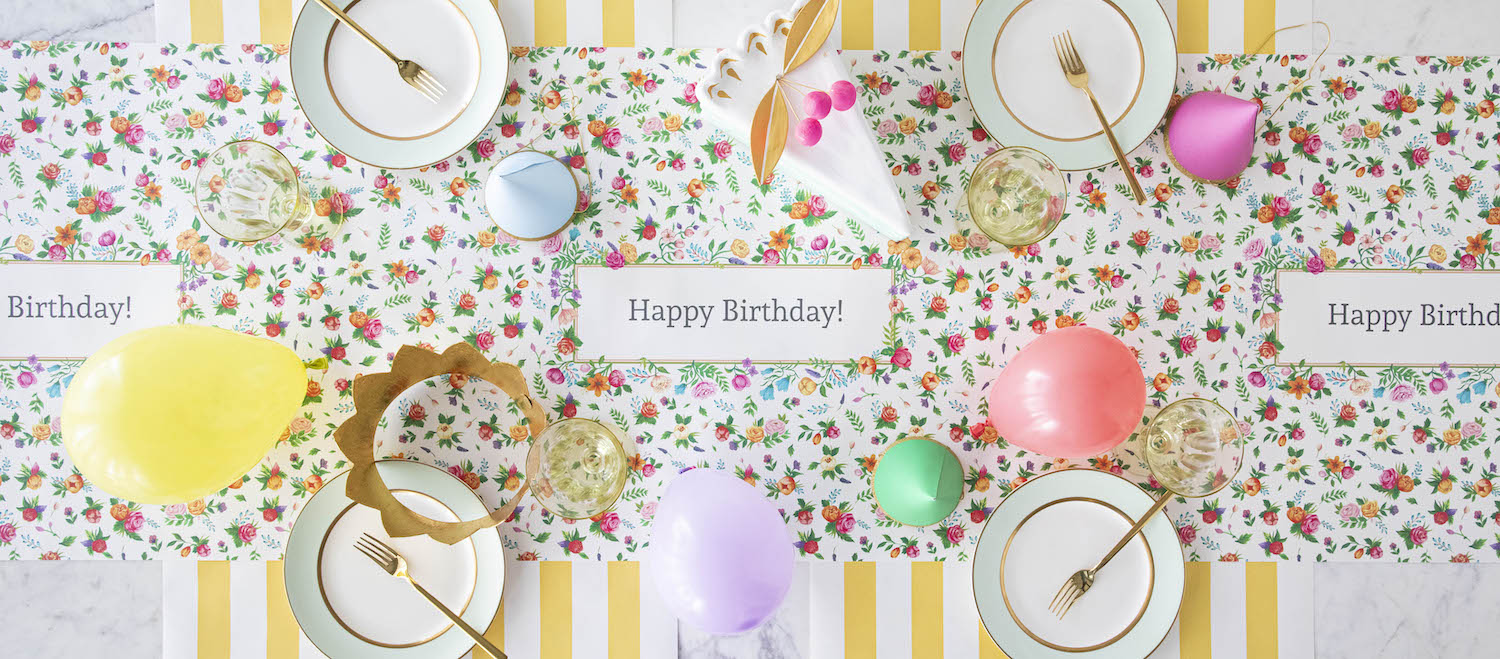 The Sweet Garden Personalized Runner under an elegant Birthday tablescape, with "Happy Birthday!" printed repeatedly in the frames, from above.