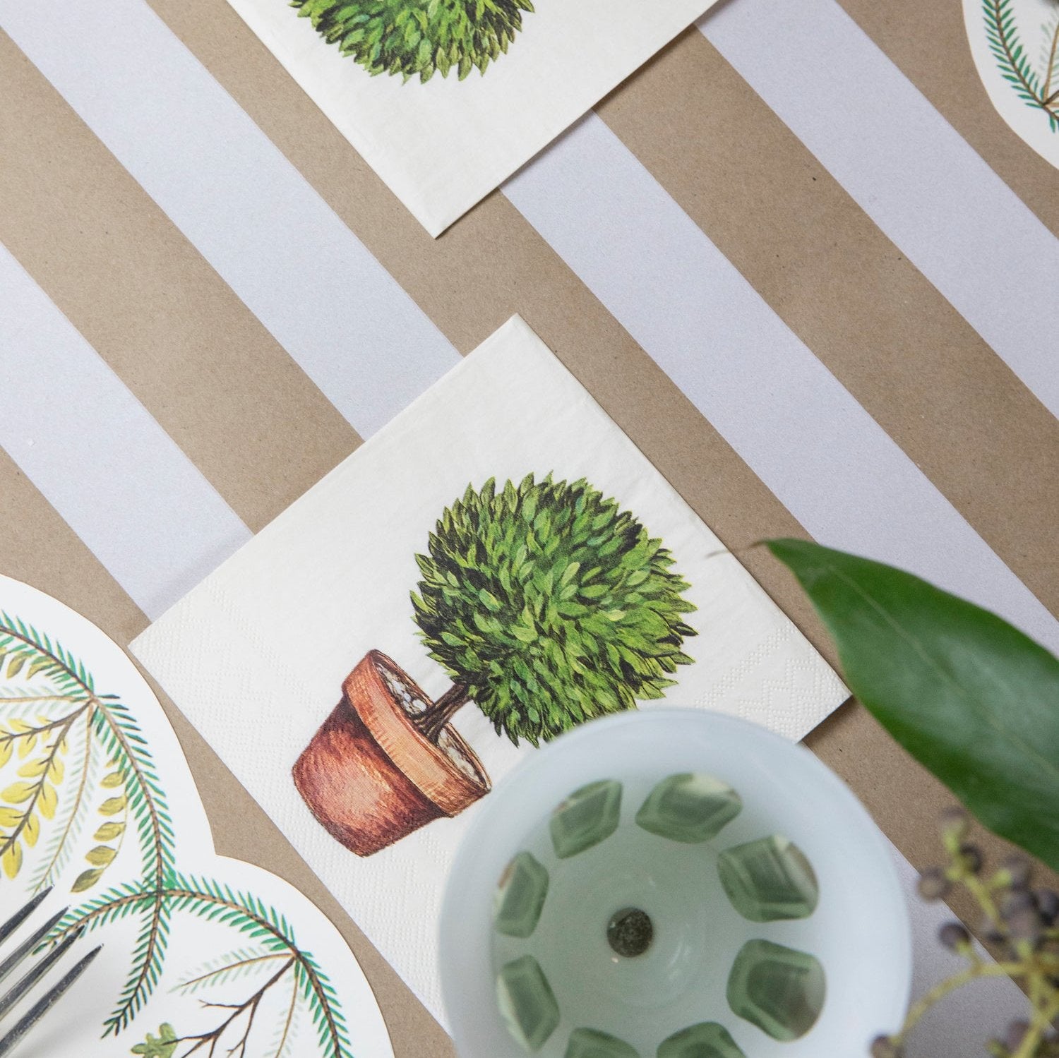A garden-themed table setting featuring Topiary Cocktail Napkins.