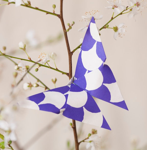 Origami Cloud of Butterflies Kit with instructions and Cambridge Imprint patterned paper on a wooden table.