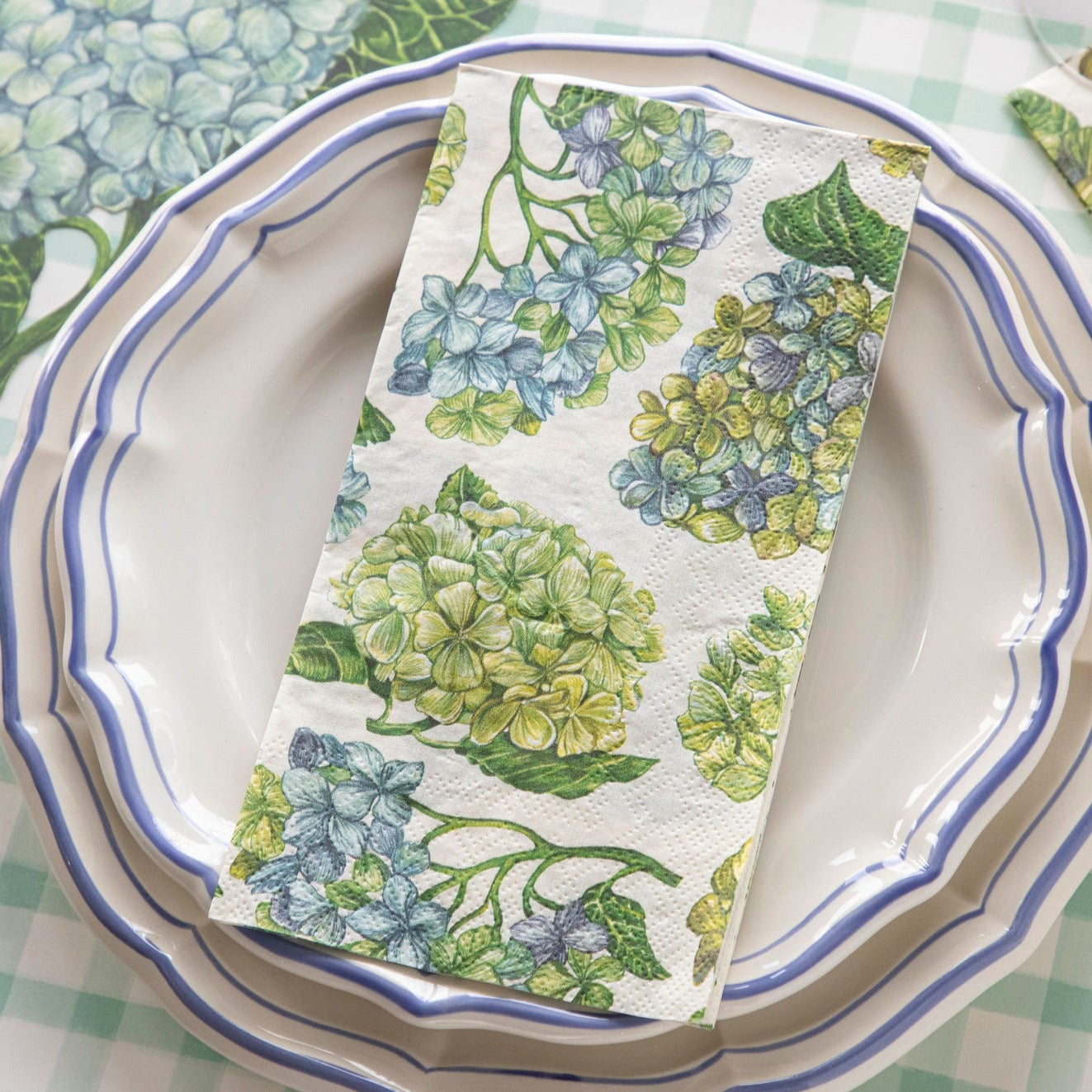 A Hydrangea Guest Napkin on the plate of an elegant floral place setting.
