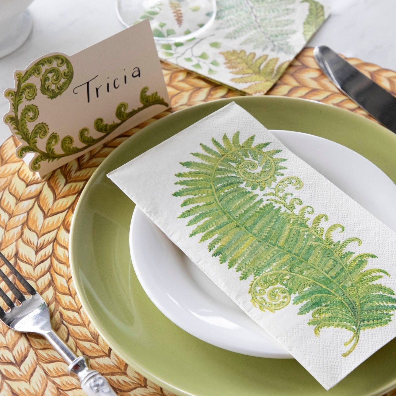 An elegant place setting with a Fern Guest Napkin on the plate, and a Fern Cocktail Napkin under the glass.