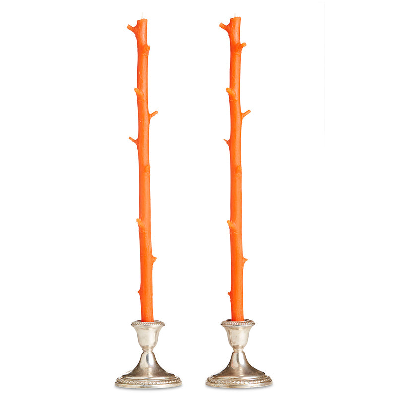 Two Stick Candles resembling tree branches, set in silver candlestick holders against a white background, with a rustic feel.
