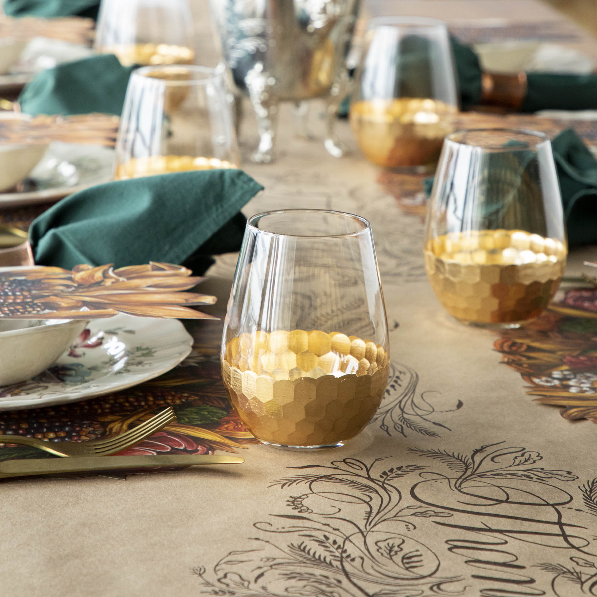 A table setting with Vitorrio Stemless Glassware plates, and napkins.