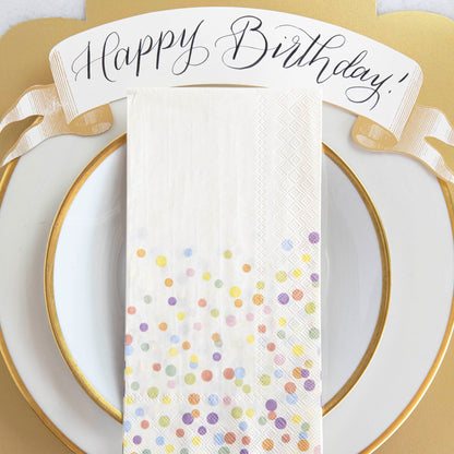 A Confetti Sprinkles Guest Napkin centered on a plate in a Birthday place setting.