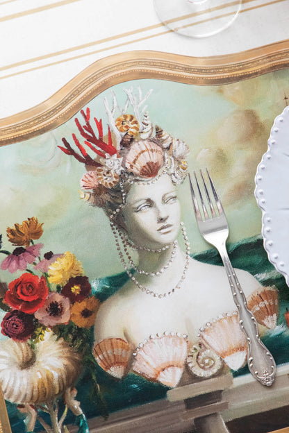Close-up of the Die-cut Goddess of the Sea Placemat under an elegant place setting, showing the artwork in detail.