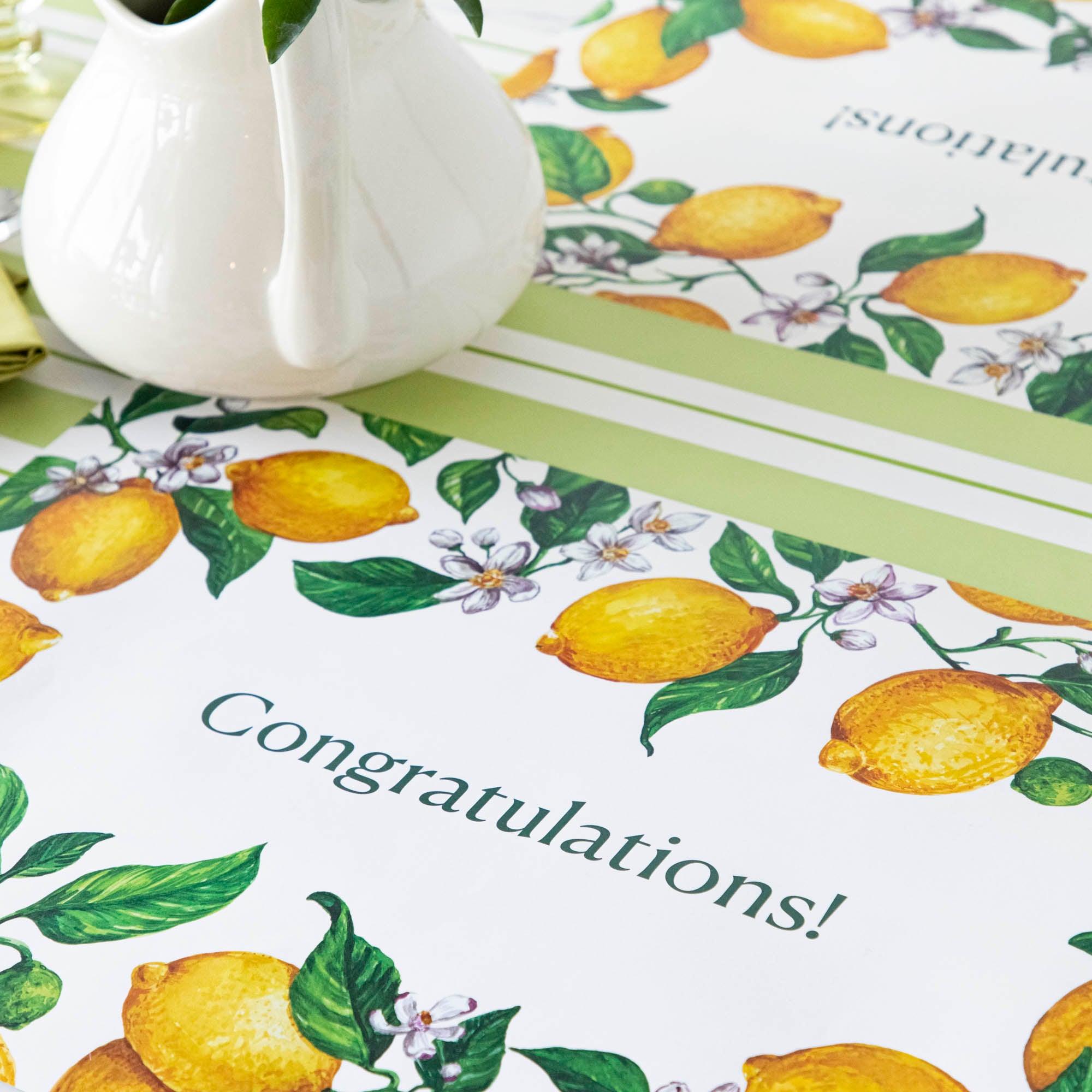 The Lemons Personalized Placemat in a table setting, with the message "Congratulations!" printed in green in the middle.