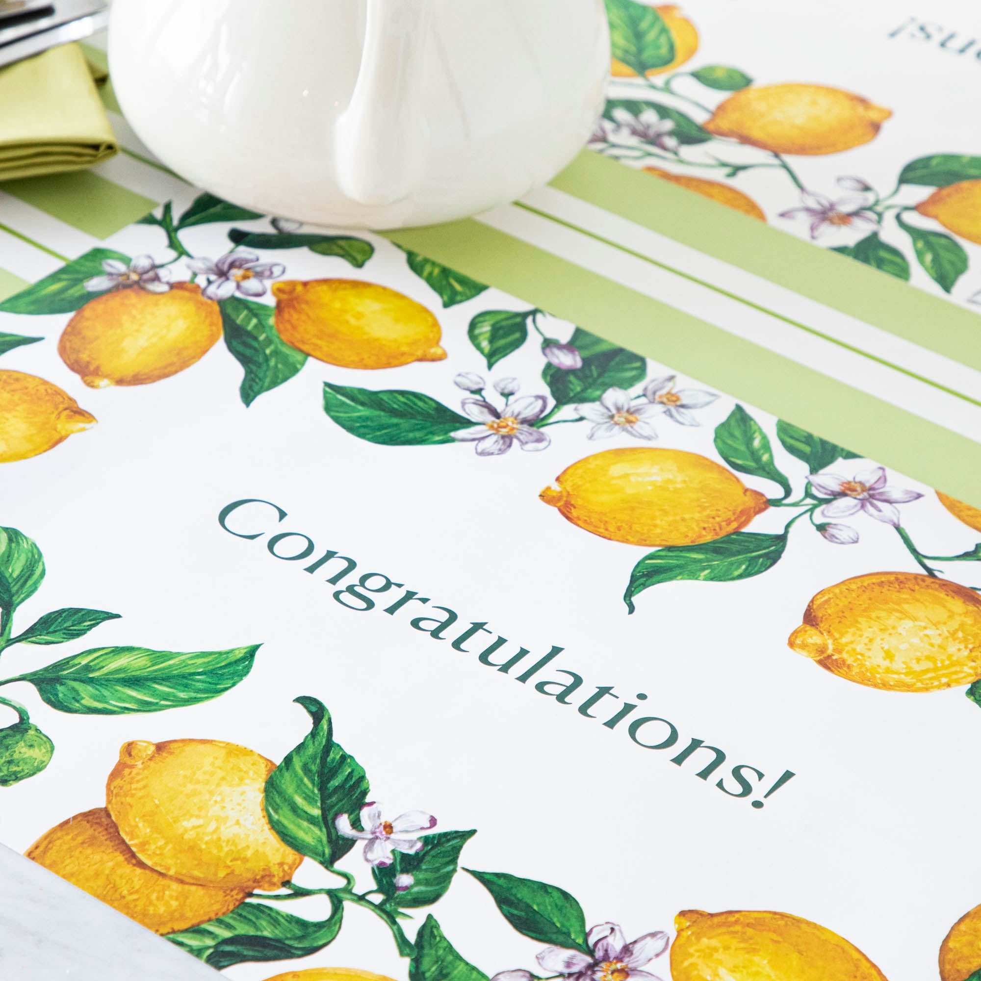 The Lemons Personalized Placemat in a table setting, with the message "Congratulations!" printed in green in the middle.