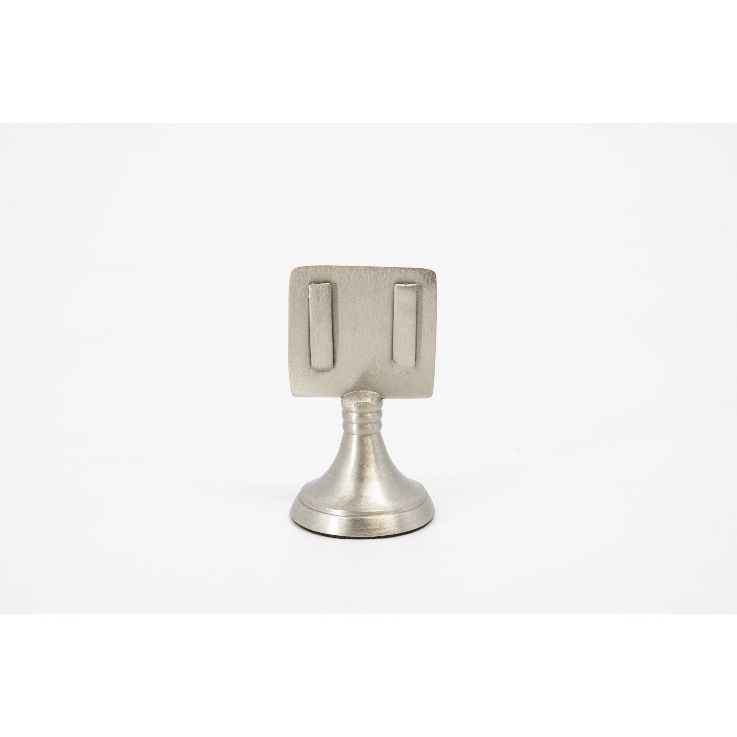 An elegant, silver, short round stand topped by a flat card-holder with two flat prongs, holding a place card reading "Francis".