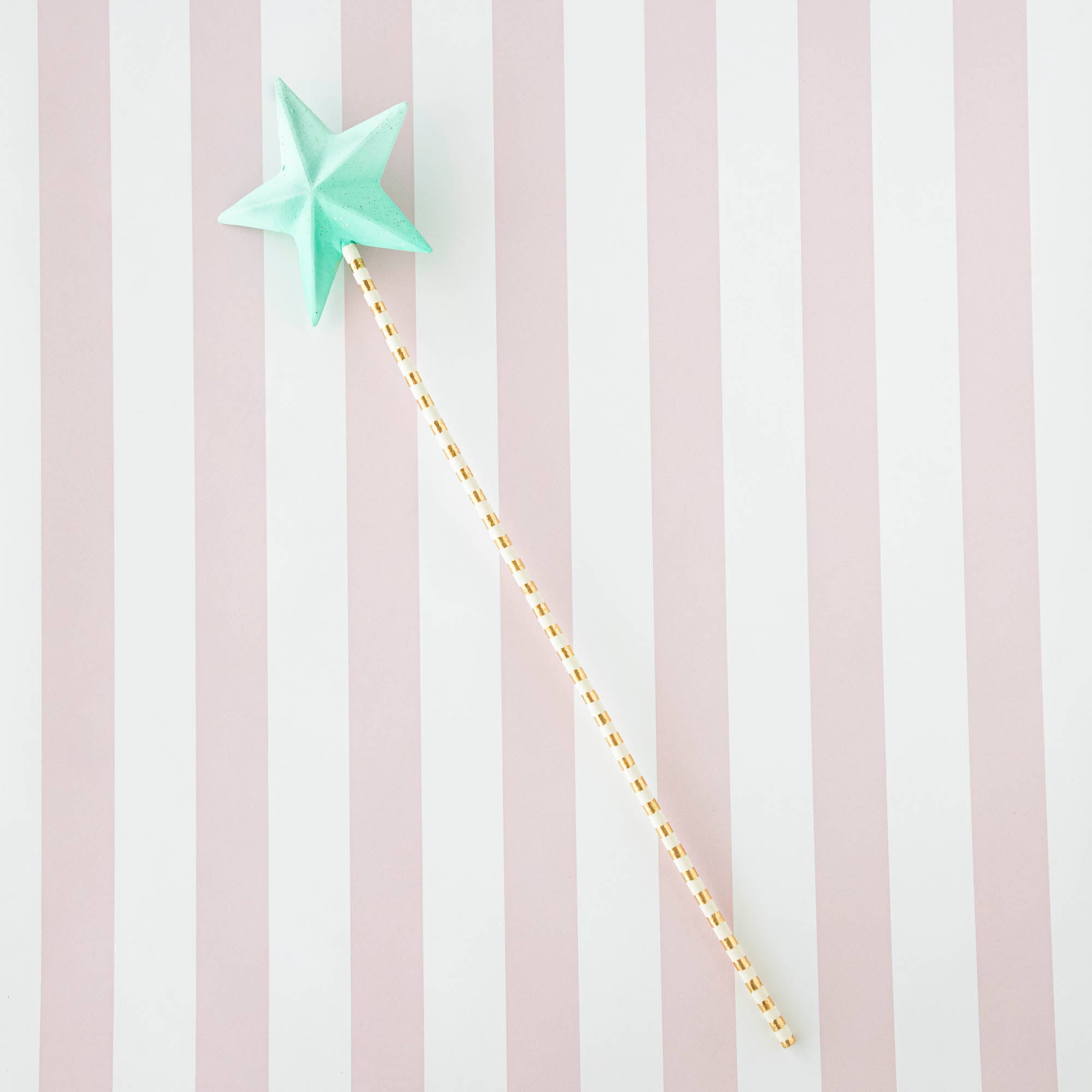 Five Glitterville Magic Wands on a striped background.