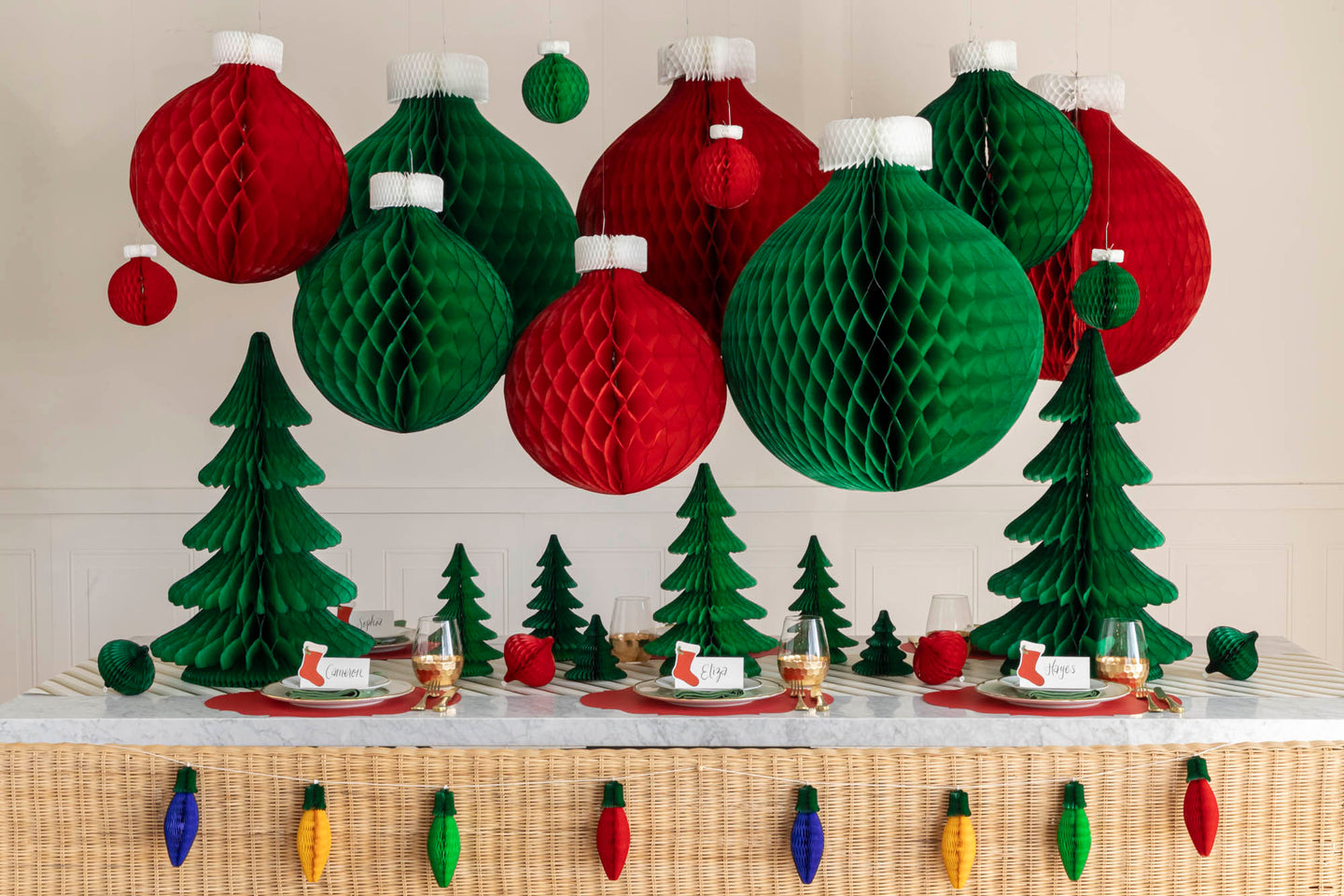A Christmas table setting with Christmas Honeycomb Paper hanging from the ceilings and scattered across the table.