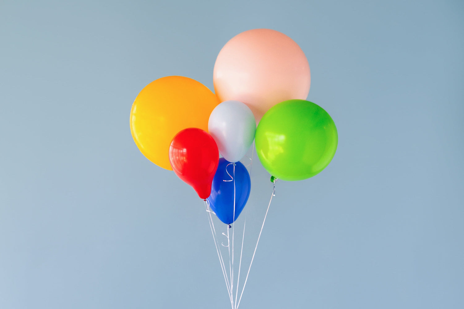 A collection of colorful balloons on a blue background. 