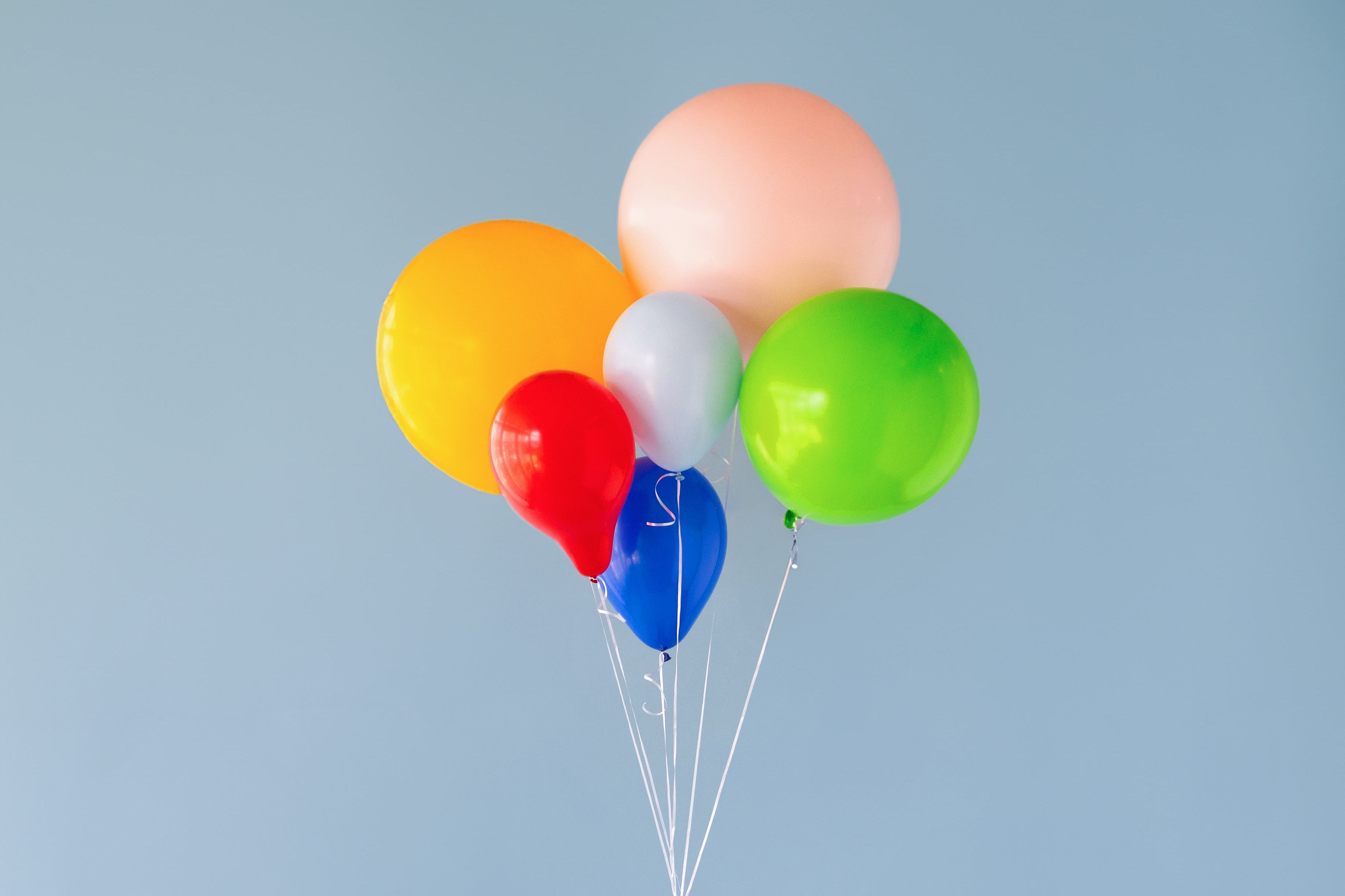 A collection of colorful balloons on a blue background. 