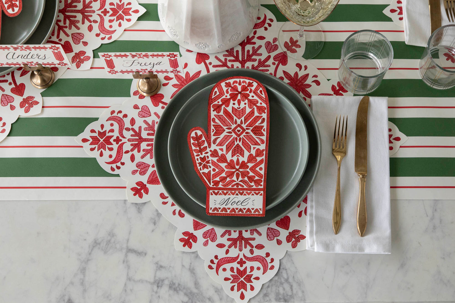 An elegant table setting featuring the Die-cut Fair Isle Snowflake Placemat, Fair Isle Mitten Table Accent and Green &amp; Red Awning Stripe Runner.