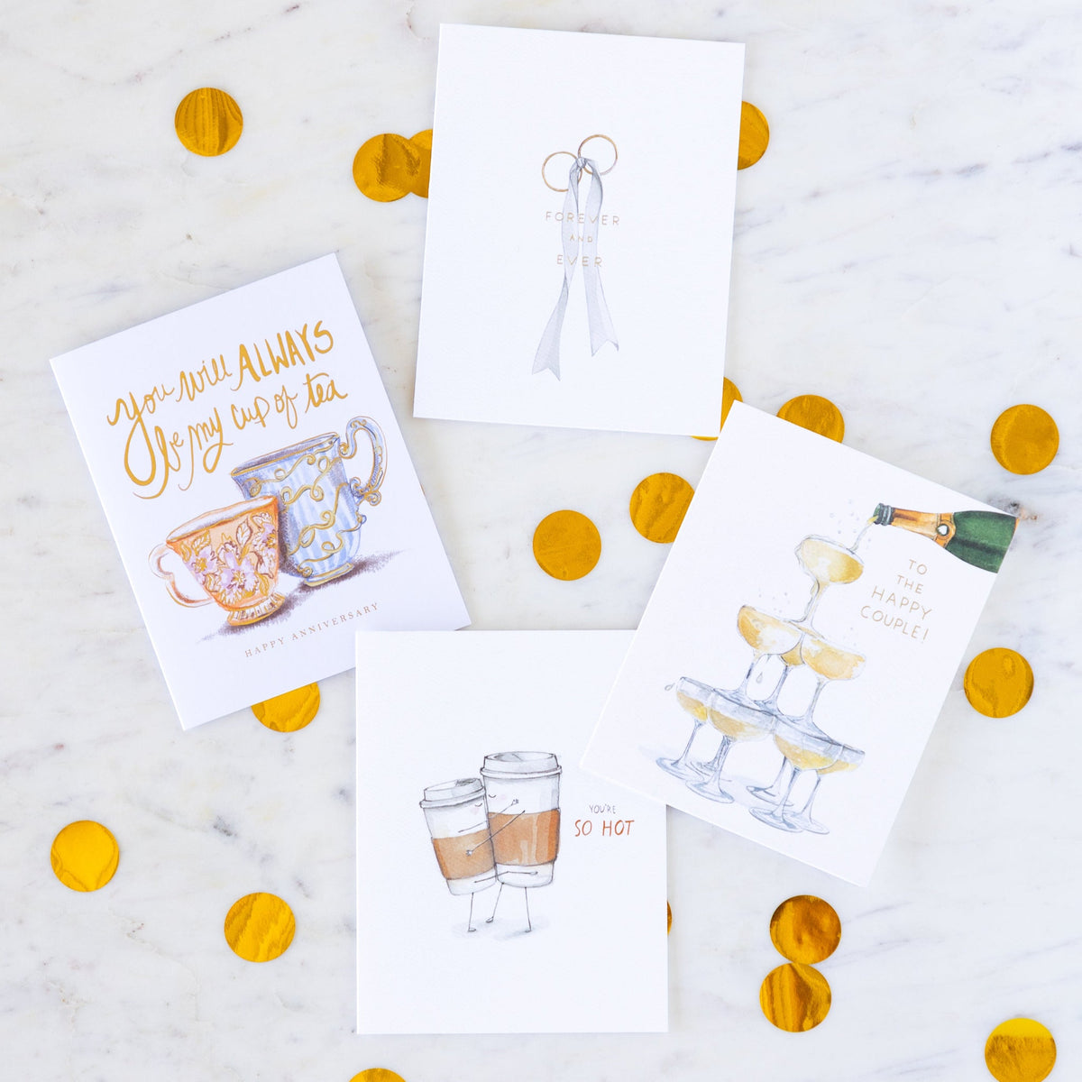 Wedding and anniversary cards arranged on a table with gold confetti.