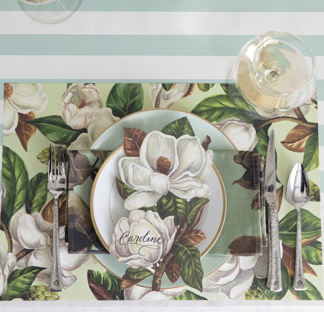 Elegant table setting with floral-patterned plates and matching tablecloth.