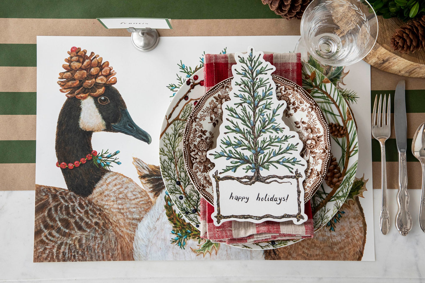 A woodland themed table setting featuring the Festive Geese Placemat, Cedar Tree Table Accent and vintage dinnerware on the Kraft Green Classic Stripe Runner.