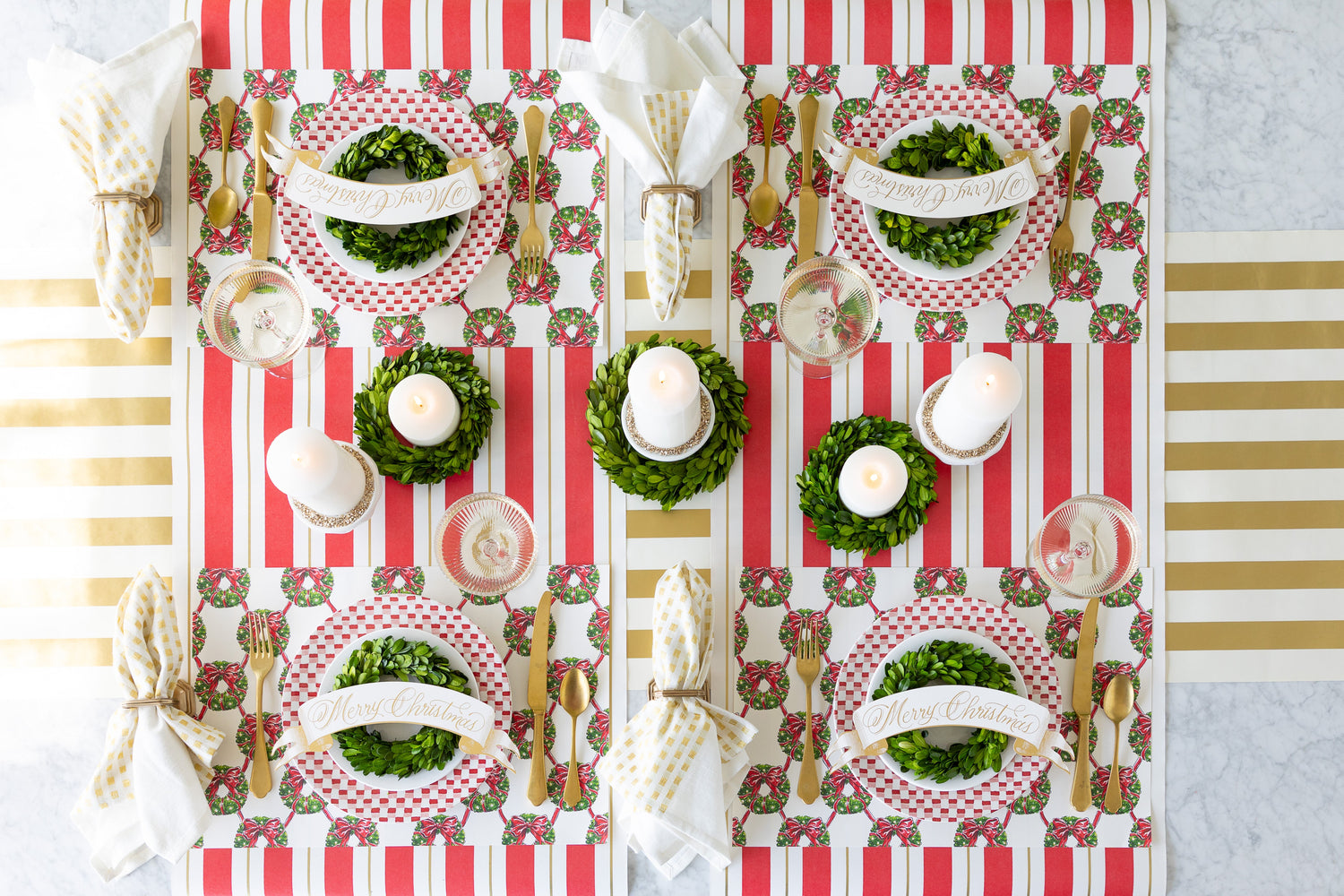 Moss Painted Check Runner under a fall table setting with Die-cut Autumn Wreath Placemats, scattered Autumn Leaf Table Accents, acorn Ornaments and candles atop wood slices.
