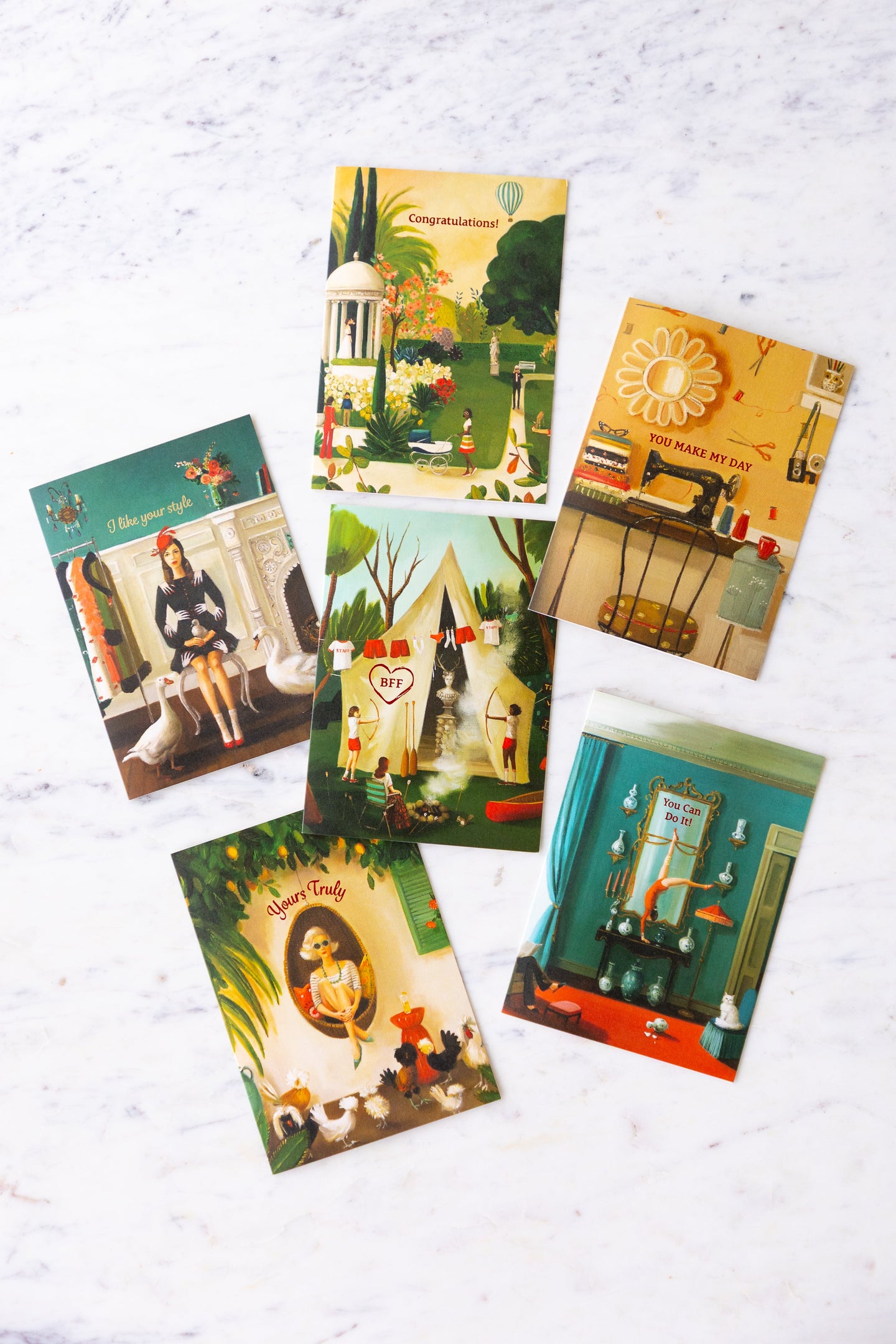 Assorted Janet Hill cards arranged on a marble table.
