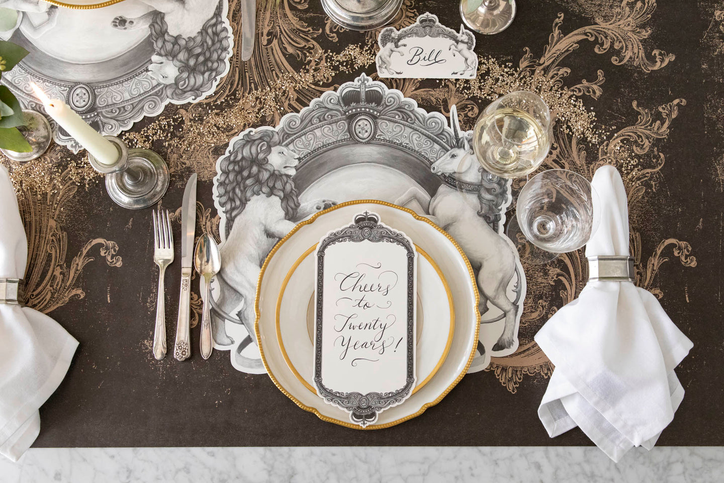 The Die-cut H&C Regal Crest Placemat styled under a regal table setting for one.
