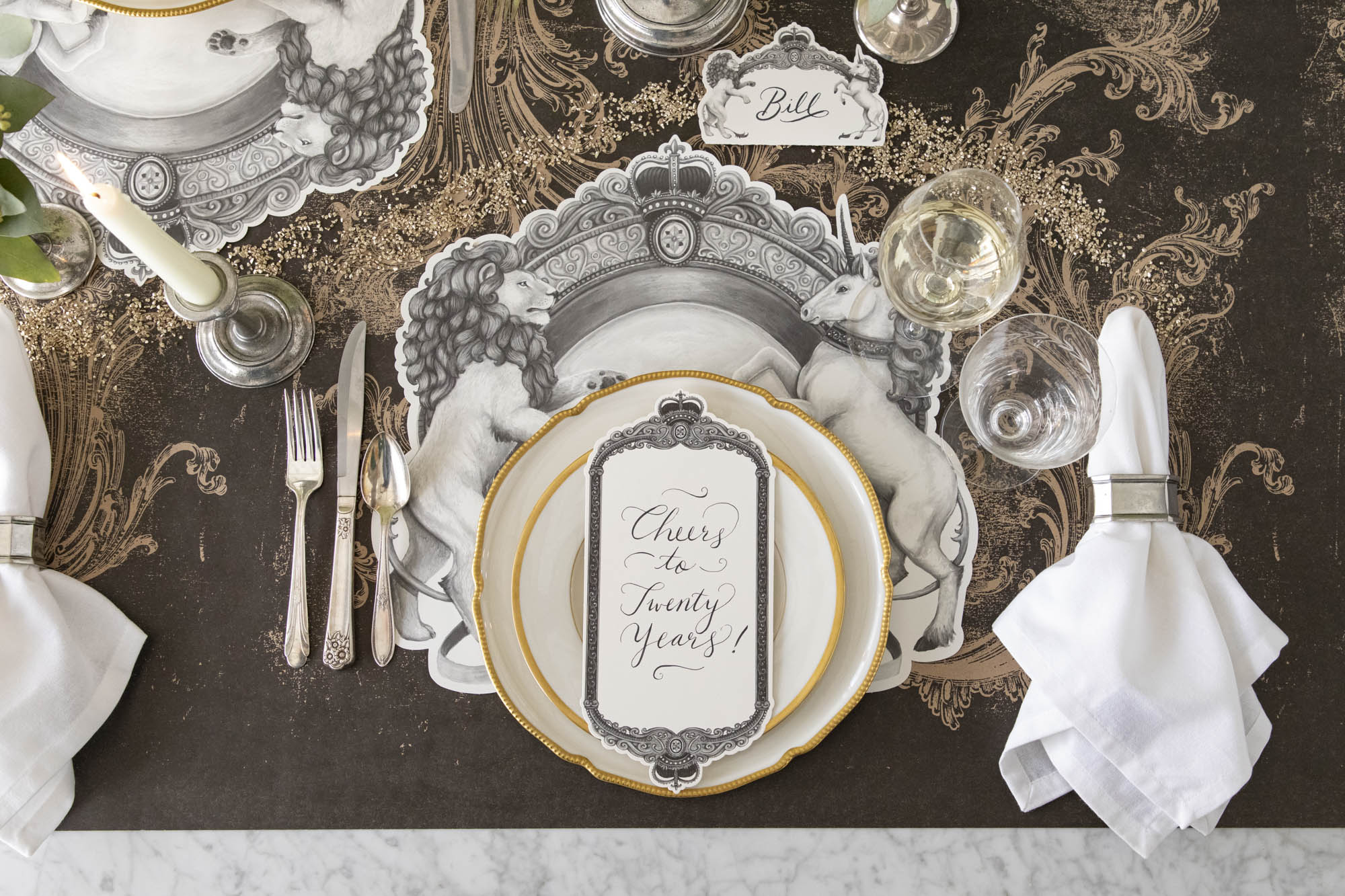 The Die-cut H&C Regal Crest Placemat styled under a regal table setting for one.