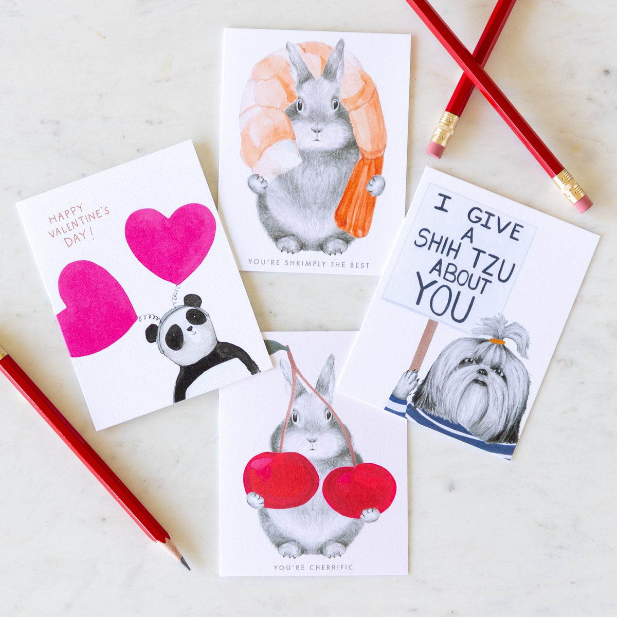 Love and friendship cards arranged on a table with pencils.