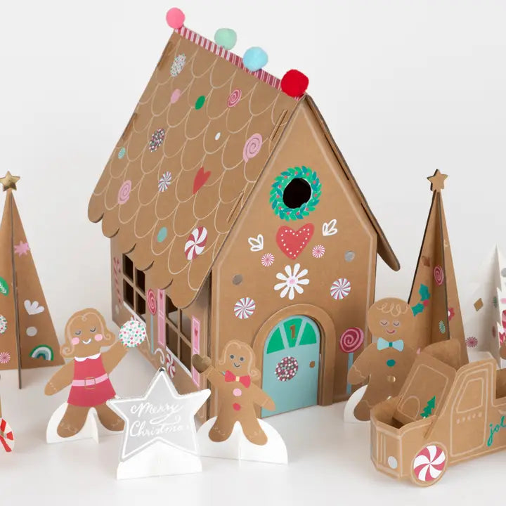 Decorative gingerbread house with gingerbread people and a truck on a white background