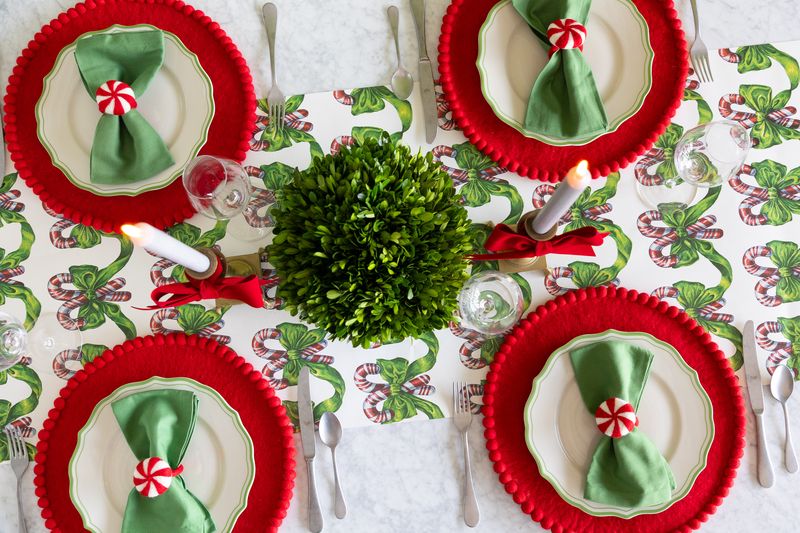 A candy cane themed runner on a holiday tablescape. 
