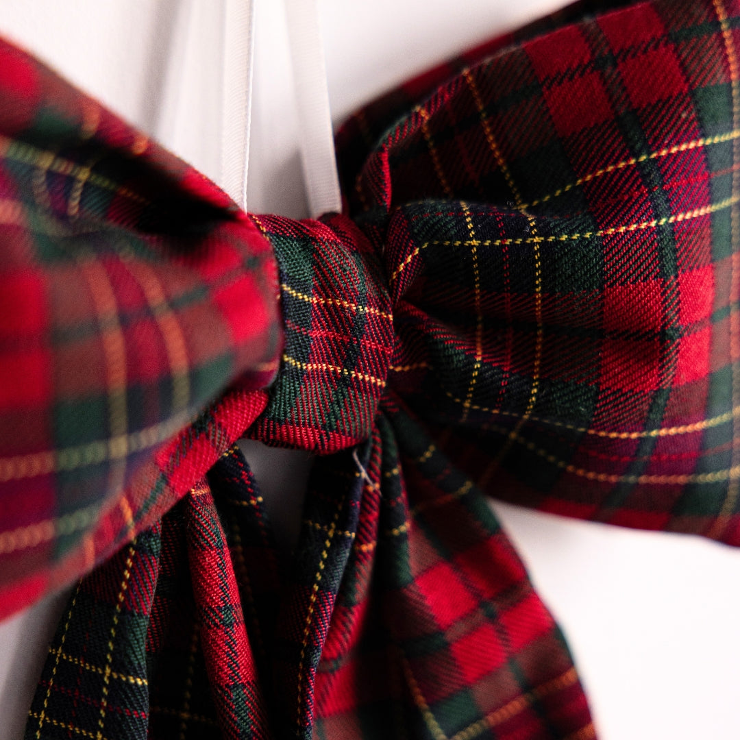 Close-up of a red and green plaid bow tie on a white background