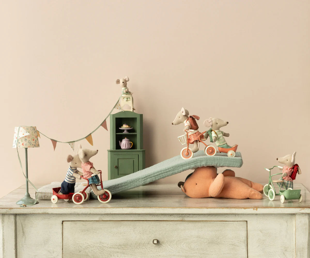 Toy mice with accessories on a wooden surface with a neutral background
