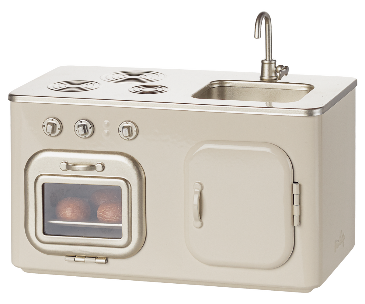 Beige kitchenette with stove, oven, and sink on a white background.