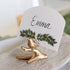 Gold bird-shaped place card holder with a name card featuring &
