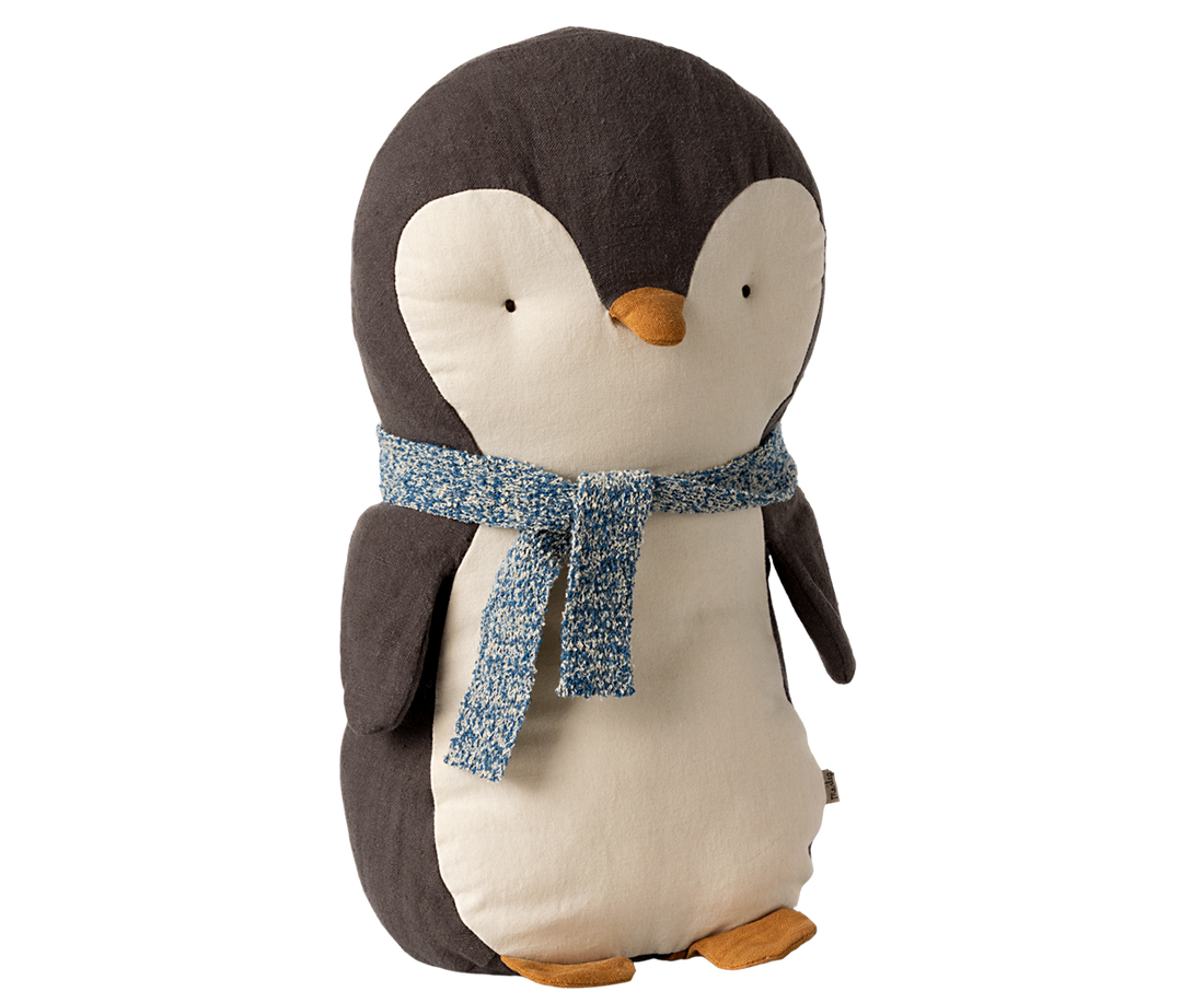 A stuffed animal penguin with a blue scarf tied around his neck.