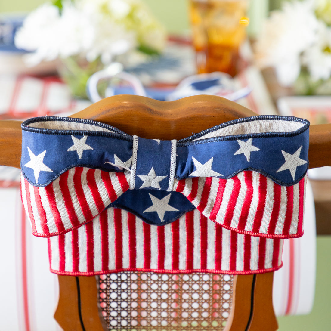 Decorative chair with American flag patterned ribbon tied in a bow on a blurred background.
