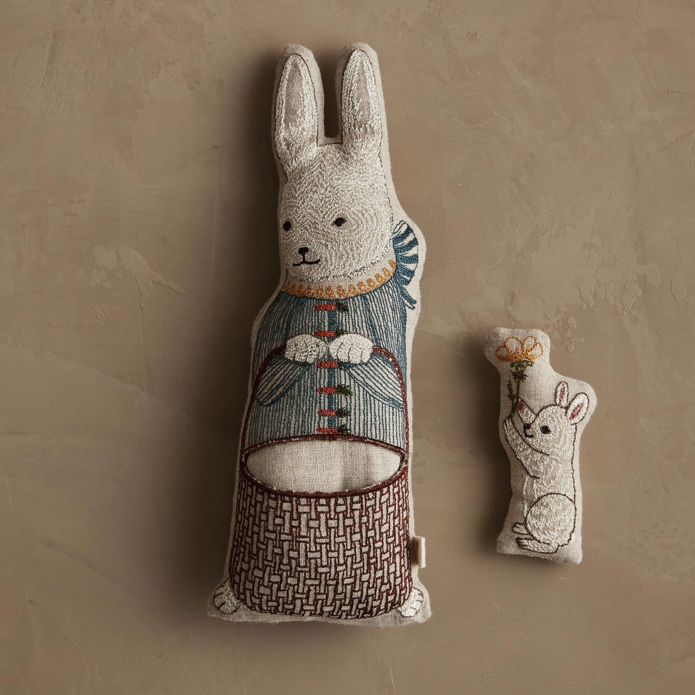 Decorative rabbit plush toys on a textured beige background.
