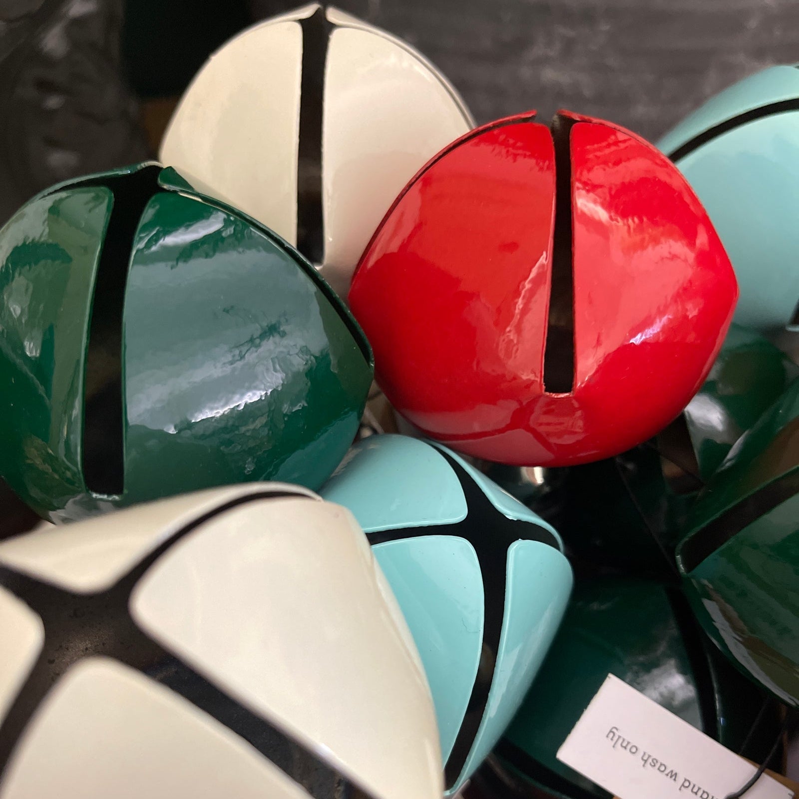 Colorful jingle bell bottle stoppers designs on a dark background.