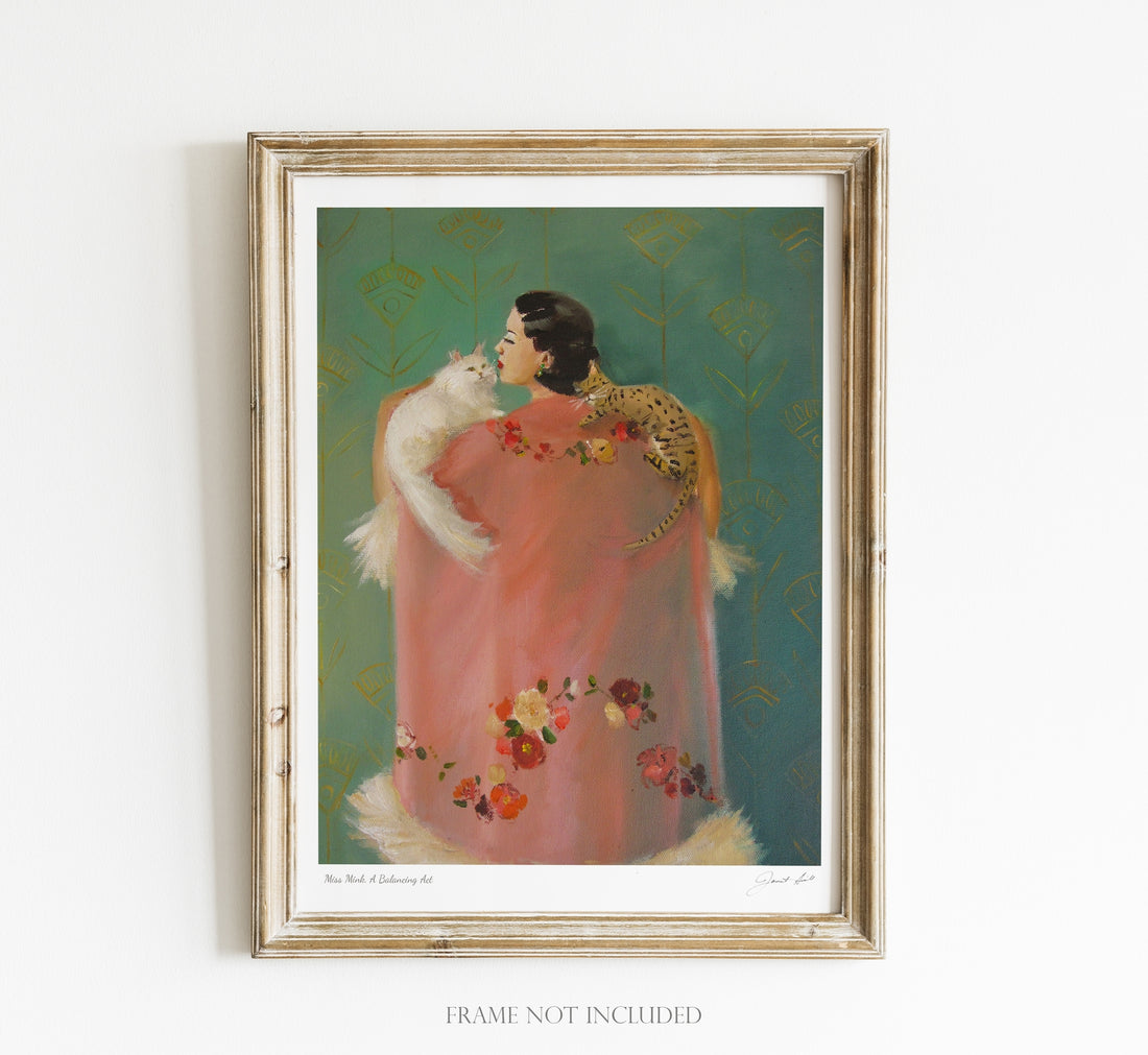 A framed print of a woman holding a cat, rendered in Janet Hill&