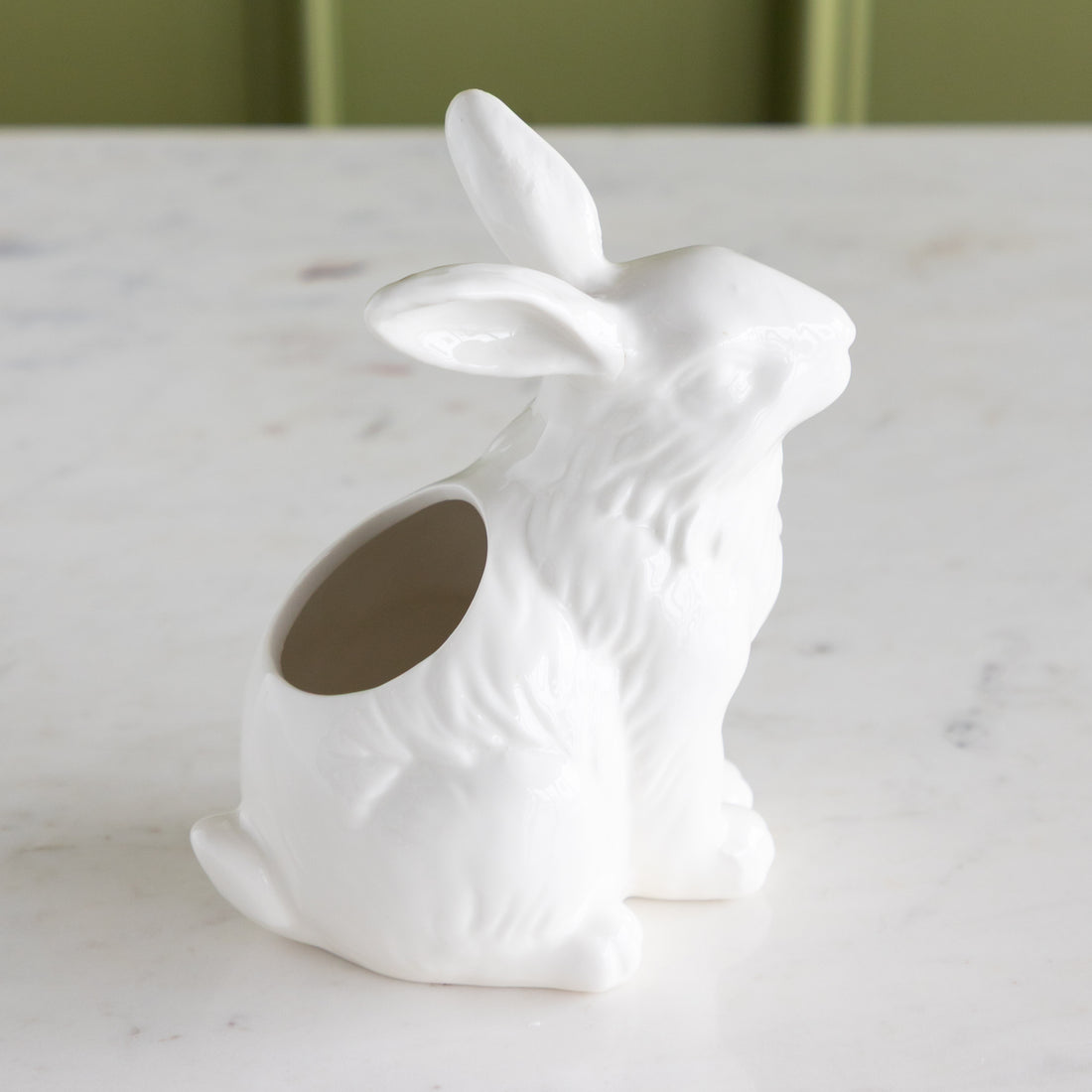 White ceramic rabbit-shaped vase on a marble surface.
