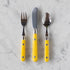 Set of three utensils with yellow handles on a marble surface.