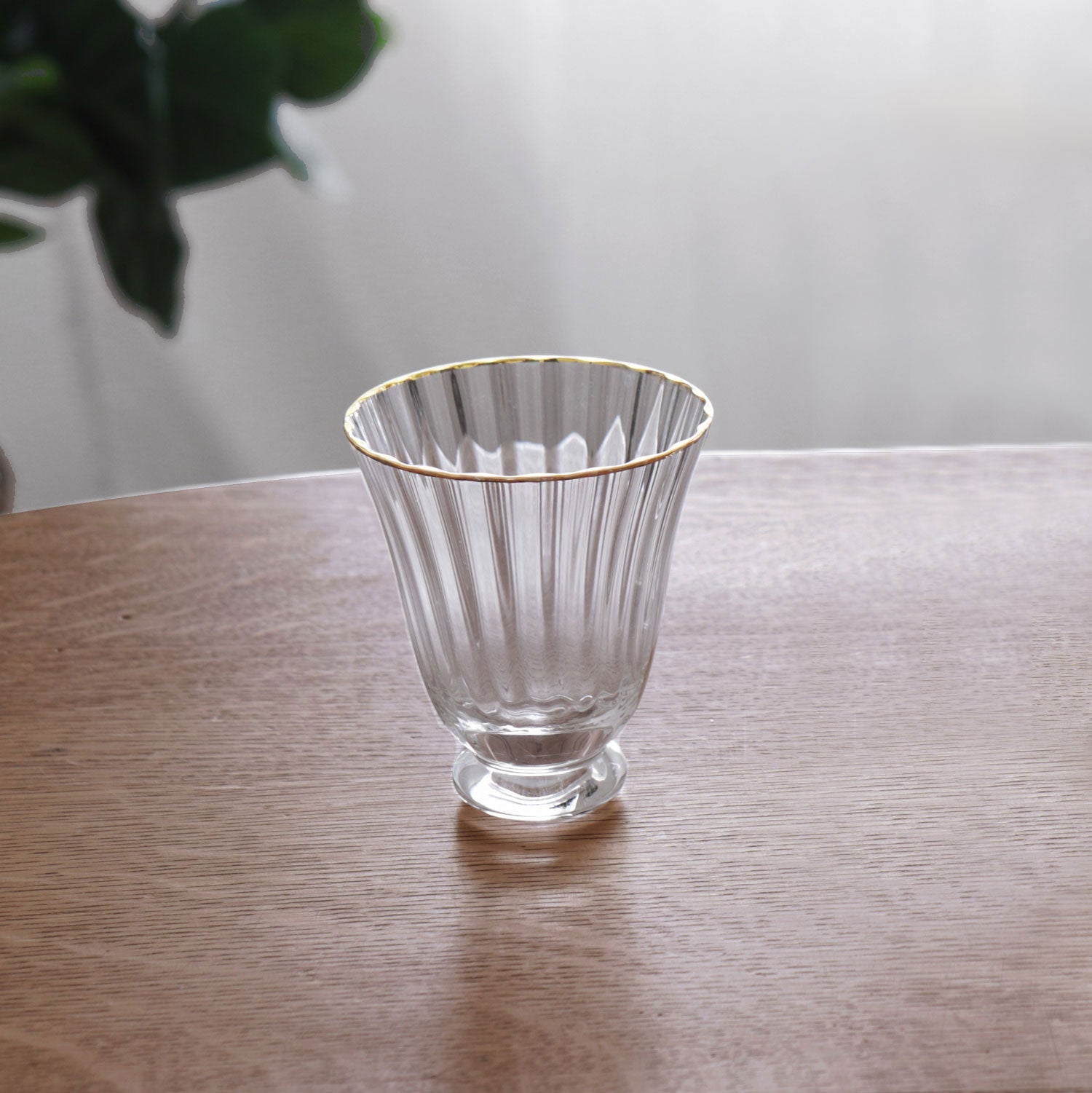 Clear glass with gold rim on a wooden surface