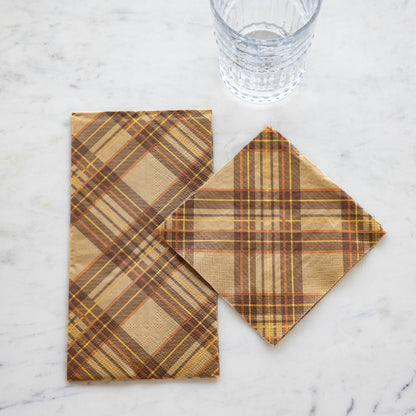 Two Hester &amp; Cook Autumn Plaid Napkins on a table next to a glass.