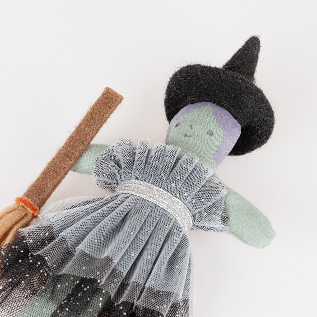Toy witch with a broomstick on a white background.