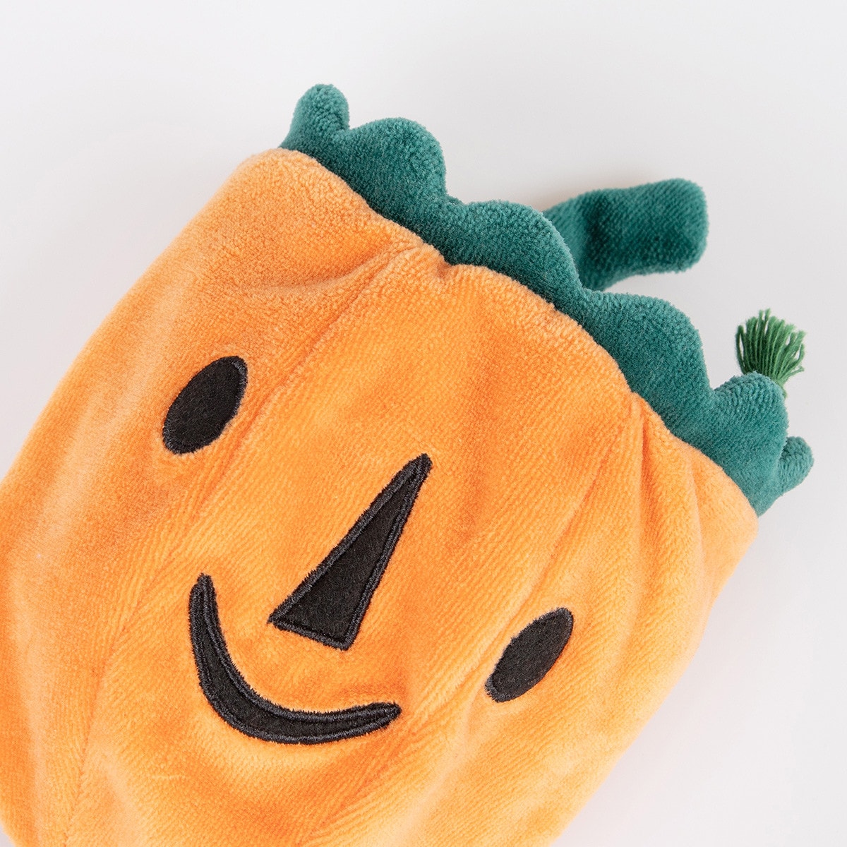 Plush pumpkin toy with a smiling face on a white background